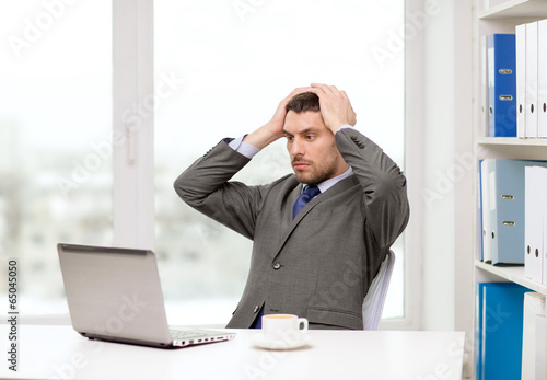 Photo: busy businessman with laptop and coffee busy businessman with laptop and coffee