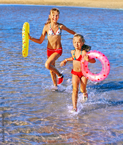 Photo: Children holding hands running on beach. Children holding hands running on beach.
