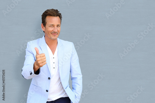 Photo: Cheerful mature man showing thumbs up Cheerful mature man showing thumbs up