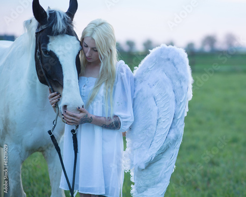 Photo: Blond angel looking after the horse Blond angel looking after the horse