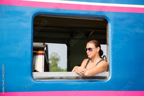 Photo: Young woman passenger looking trough window Young woman passenger looking trough window