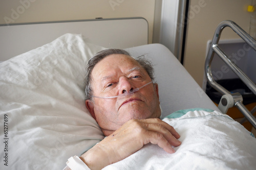 Man in hospital bed - 65277699