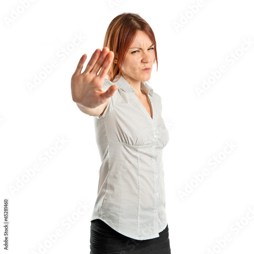 Photo: Pretty woman making stop sign over white background Pretty woman making stop sign over white background
