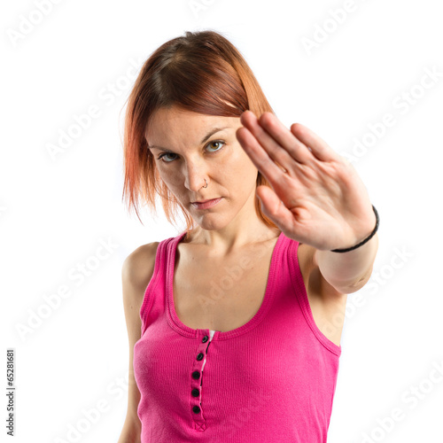 Photo: Pretty woman making stop sign over white background Pretty woman making stop sign over white background