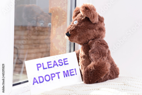 Photo: Toy-bear looking out window close-up Toy-bear looking out window close-up