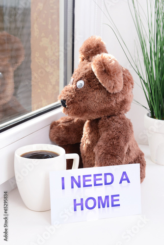 Photo: Toy-bear looking out window close-up Toy-bear looking out window close-up