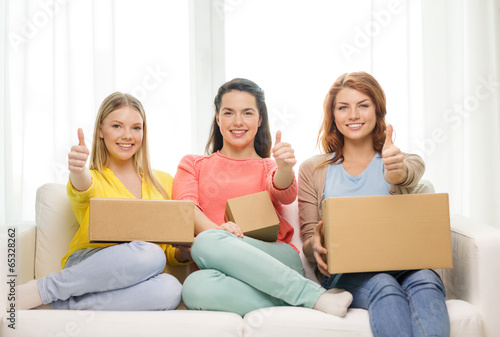 Photo: smiling teenage girls with cardboard boxes at home smiling teenage girls with cardboard boxes at home