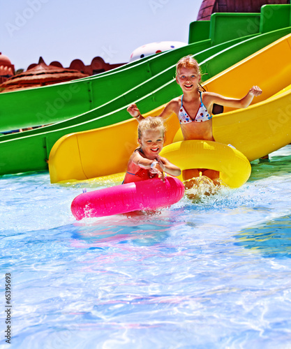 Photo: Child on water slide at aquapark. Child on water slide at aquapark.