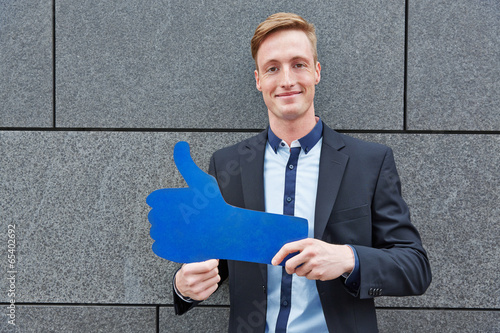 Photo: Mann hält großen blauen Daumen hoch Mann hält großen blauen Daumen hoch