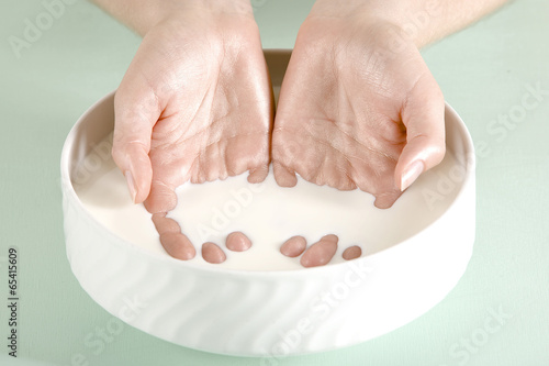Photo: Hände einer jungen Frau in einer Schüssel Milch, Schönheit Hände einer jungen Frau in einer Schüssel Milch, Schönheit