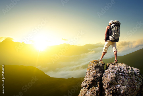 Photo: Tourist on rock. Sport and active life concept Tourist on rock. Sport and active life concept