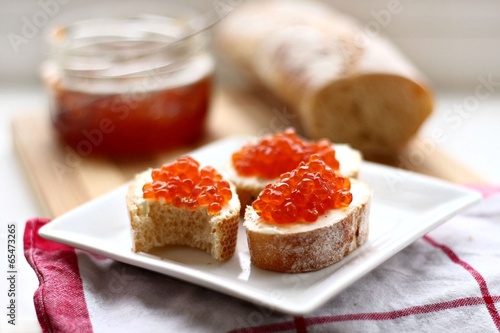 Photo: Red caviar in spoon on a baguette Red caviar in spoon on a baguette