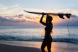 woman surfer with surfboard on tropical beach at sunset woman surfer with surfboard on tropical beach at sunset