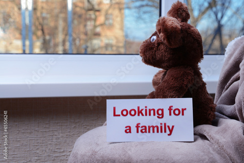 Photo: Toy-bear looking out window close-up Toy-bear looking out window close-up