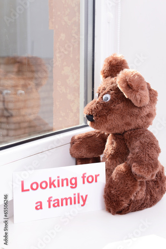 Photo: Toy-bear looking out window close-up Toy-bear looking out window close-up