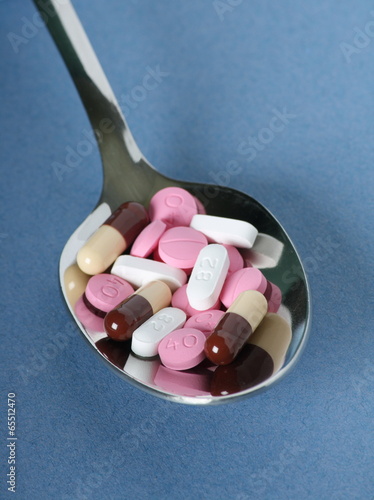 Photo: Various pills, tablets and capsules on a silver spoon Various pills, tablets and capsules on a silver spoon