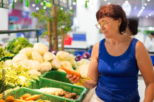 Photo: woman buys a carrot woman buys a carrot