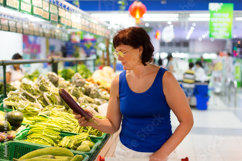 Photo: woman buys eggplant woman buys eggplant