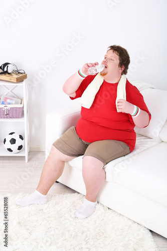 Photo: Large fitness man working out at home Large fitness man working out at home