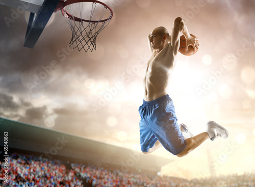 Photo: Basketball player in action on background of sky and crowd Basketball player in action on background of sky and crowd