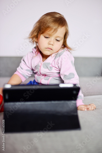 Photo: toddler girl using tablet pc toddler girl using tablet pc