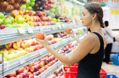 Photo: Woman buying apples in a supermarket Woman buying apples in a supermarket