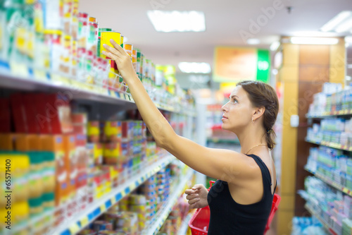 Photo: A woman buys canned A woman buys canned