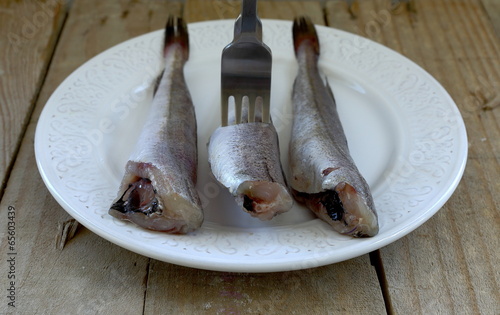 Photo: Fishes and fork on plate Fishes and fork on plate