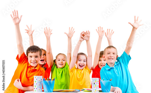Photo: Group of children in colored t-shirts with raised hands. Group of children in colored t-shirts with raised hands.