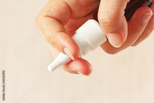 Photo: Female hand holding a nasal spray close up Female hand holding a nasal spray close up