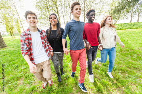 Photo: Multiethnic Group of Teenagers Walking at Park Multiethnic Group of Teenagers Walking at Park