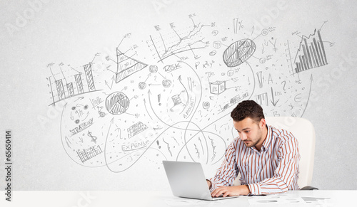 Photo: Business man at desk with hand drawn charts Business man at desk with hand drawn charts
