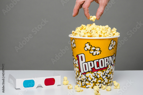 Photo: Hand reaching for popcorn Hand reaching for popcorn