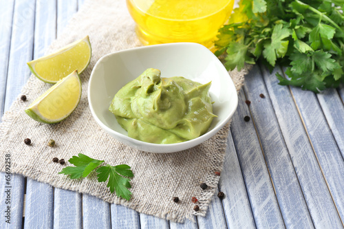 Photo: Fresh guacamole in bowl on wooden table Fresh guacamole in bowl on wooden table