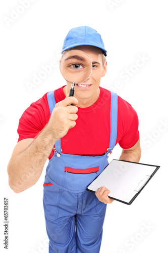Photo: Male mechanic looking through magnifying glass Male mechanic looking through magnifying glass