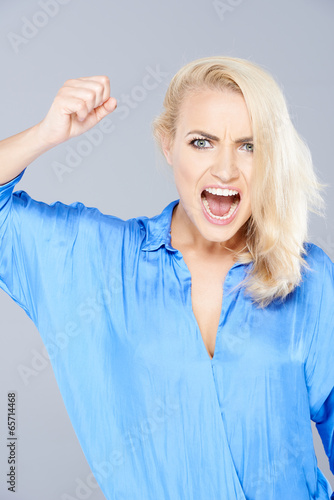 Photo: Temperamental woman raising her fist in anger Temperamental woman raising her fist in anger