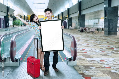 Photo: Excited tourists holding billboard Excited tourists holding billboard