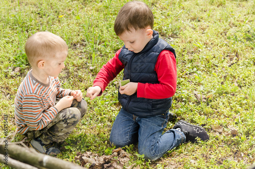 Photo: Two small boys lighting a fire in woodland Two small boys lighting a fire in woodland