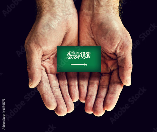 Photo: saudi arabia flag in hands saudi arabia flag in hands
