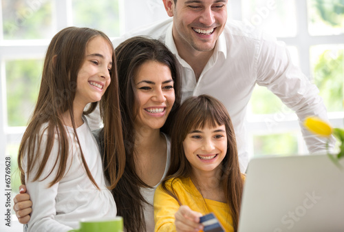 Photo: Happy family looking at laptop Happy family looking at laptop