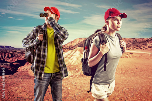 Photo: Young trekking couple with binocular in the desert. Young trekking couple with binocular in the desert.