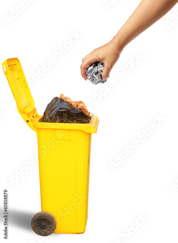 Photo: Hand throwing paper into the yellow recycle trash Hand throwing paper into the yellow recycle trash