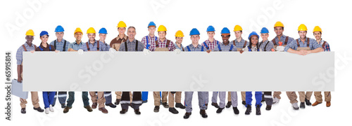 Photo: Multiethnic Manual Workers Holding Blank Banner Multiethnic Manual Workers Holding Blank Banner