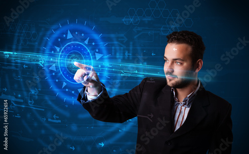 Photo: Handsome tech guy pressing high technology control panel screen Handsome tech guy pressing high technology control panel screen