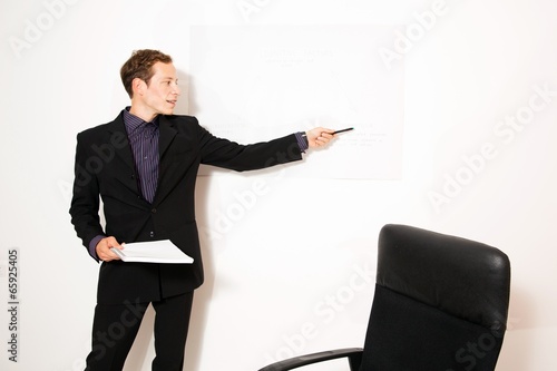 Photo: Young business dressed male holding presentation Young business dressed male holding presentation