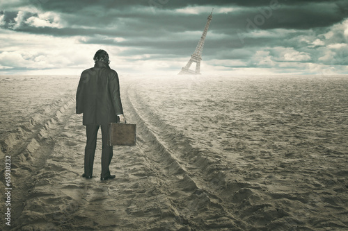 Photo: Businessman in a surreal and desert beach Businessman in a surreal and desert beach
