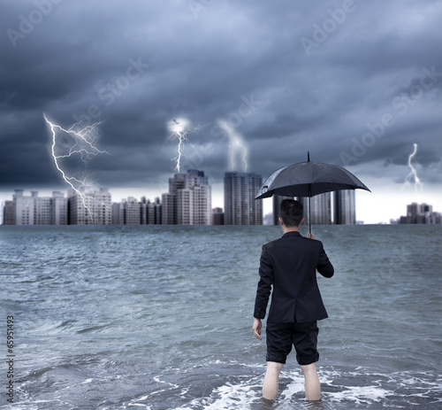 Photo: business man holding an umbrella with thundershower background business man holding an umbrella with thundershower background