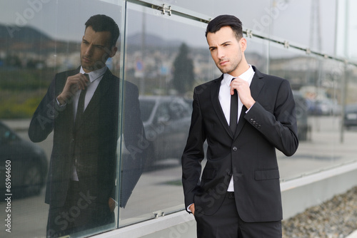 Photo: Young businessman near a office building Young businessman near a office building