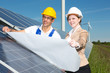 Photovoltaic engineers with construction plan at solar panels Photovoltaic engineers with construction plan at solar panels