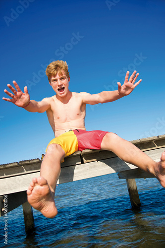 Photo: Fröhlicher Teenager sitzt auf Steg Fröhlicher Teenager sitzt auf Steg